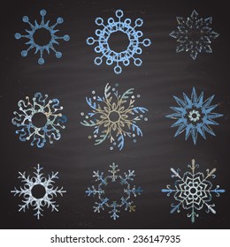  Colored set of snowflakes drawn in chalk on a blackboard.