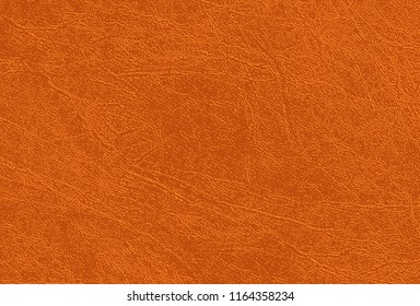 Colored  skin texture, natural or faux orange leather background. Light brown leatherette, closeup. 