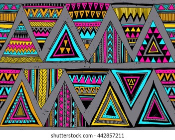 Colored tribal vector seamless pattern with doodle triangles. Abstract geometric art print. Traditional ethnic folk motif. Aztec vector background. Hand drawn. Wallpaper, textile design, fabric