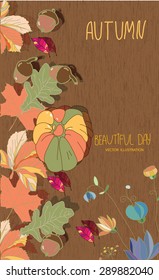 colorful autumn background with different leaves and acorns with pumpkin and flowers on a wooden texture with the words autumn and beautiful day
