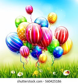 Colorful balloons and confetti in front of spring landscape