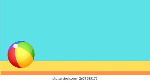 Colorful beach ball on sand with clear sky background, summer fun concept.