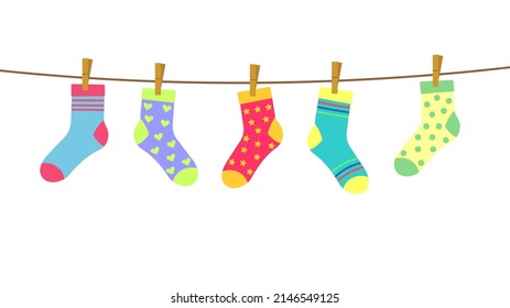 colorful bright socks on a rope with clothespins against a background of sky and clouds. Cute clothes. 