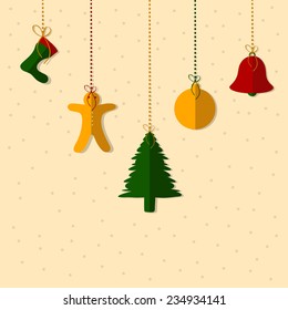 Colorful Christmas ornaments hanging on beige background for Merry Christmas and other occasion celebrations.