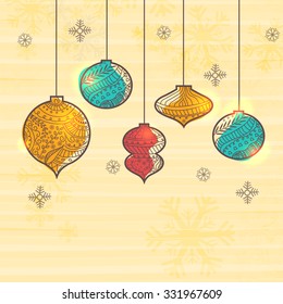 Colorful creative Xmas Balls hanging on Snowflakes decorated background for Merry Christmas celebration.