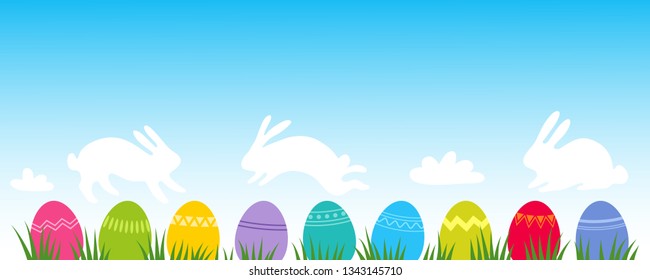 Colorful Easter Eggs on grass with clouds shaped like Easter bunnies, flat design, horizontal banner with blue sky backdrop and room for text