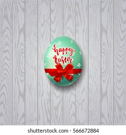 Colorful egg with bow and ribbon. Hand drawn calligraphy "happy Easter"   