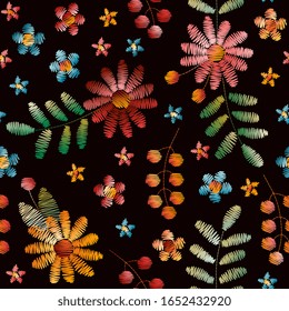 Colorful embroidery seamless pattern. Bright flowers, leaves and berries on black background. Beautiful fancywork.