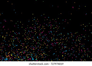 Colorful explosion of confetti. Colored glitter and sprinkles. Grainy abstract holiday illustration. Isolated on black background. Multi colored texture. Vector.
