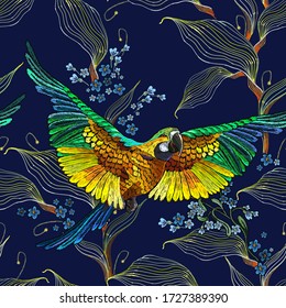 Colorful flying ara parrots, blue flowers and palm leaves seamless pattern. Macaws, jungle birds. Fashionable template for design of clothes, textiles. Paradise forest background 