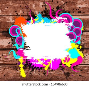 colorful frame with splashes on a brown wooden wall background 