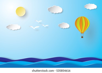 Colorful hot air balloon and cloud over the sea. paper art style.