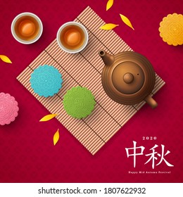 Colorful mooncakes on bamboo mat, teapot and teacup. Chinese translation is blessing and Mid Autumn. Top view of tea ceremony with cookies, pot and yellow petals. China holiday poster design.