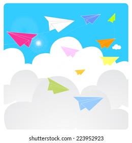 colorful origami paper planes fly on a blue sky during a clear sunny day