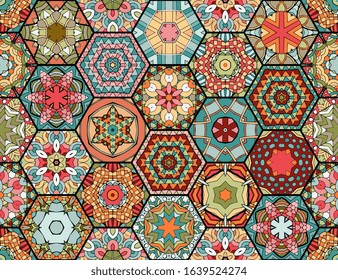 Colorful patchwork pattern in ethnic style. Hexagonal ceramic tiles with bright ornament. Seamless vector design.