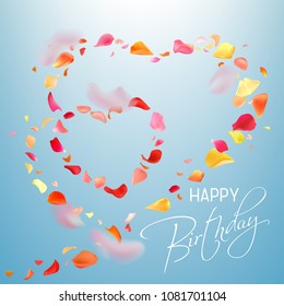 Colorful photo realistic rose petals flying in heart shape and white hand writting text Happy Birthday on a light blue background. Petals in different shape and focal distance, big, small, blurry.