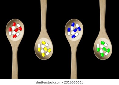 Colorful pills-capsules of medicines, vitamins or supplements in wooden kitchen spoons on black background. Concept of medicine and health