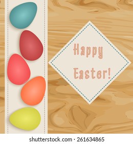 Colorful  postcard for Easter holidays. Eggs on wooden surface with napkin