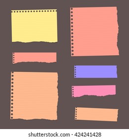 Colorful ripped lined blank note paper are stuck on dark wall