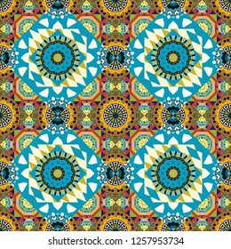 Colorful seamless pattern in mosaic style. Vector patchwork quilt pattern. Textile fabric paper print. Abstract hand drawn art, stylized floral doodle background in green, orange and blue colors.