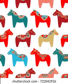 Colorful seamless vector pattern with Scandinavian Christmas dala horses on white background