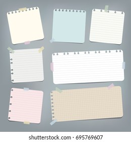 Colorful striped, ruled note, copybook, notebook paper stuck with sticky tape on grey background.