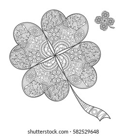 Coloring book shamrock on St. Patrick's Day.Black and white clover with four leaves. Decorated with hand draw doodle pattern. Vector sign of good luck.