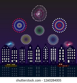Colourful fireworks display on the night sky in the cityscape of Amsterdam with the reflection on water in the Amstel river canal and boats. 
