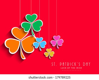 Colourful hanging clover leaves on red background, can be use as sticker, tag or label for Happy St. Patrick's Day celebrations.