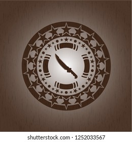 combat knife icon inside badge with wood background