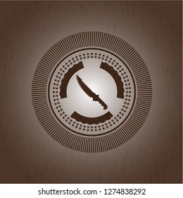 combat knife icon inside badge with wood background