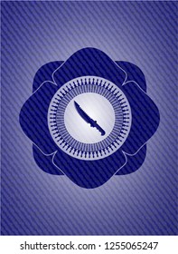 combat knife icon inside emblem with denim texture
