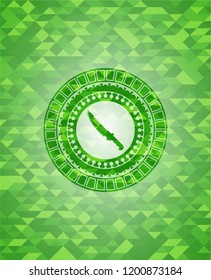 combat knife icon inside green emblem with mosaic background