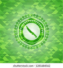combat knife icon inside green emblem with triangle mosaic background