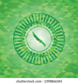 combat knife icon inside green emblem with triangle mosaic background