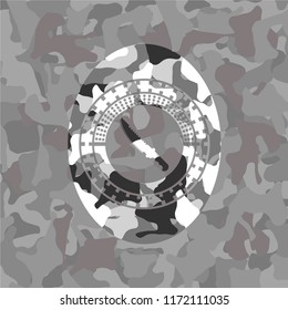 combat knife icon inside grey camouflage emblem
