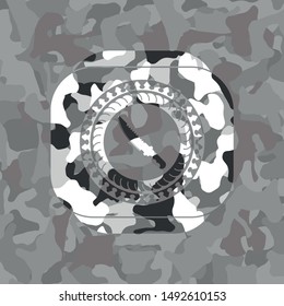combat knife icon inside grey camouflage emblem