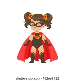 Comic brave girl kid in superhero black costume with star, mask and developing in the wind red cloak, standing on legs wide apart.