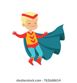 Comic cute blond kid in colorful superhero costume with red headband and developing cloak, jumping with hands up. Vector cartoon flat super boy character.