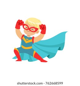 Comic happy kid in superhero costume, red mask and gloves, blue cape developing in the wind, posing and showing muscles.