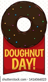 Commemorative ribbon with greeting message and delicious donut with chocolate glaze and candy sprinkles ready to be eaten during Doughnut Day.