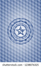 communism icon inside blue badge with geometric pattern background.