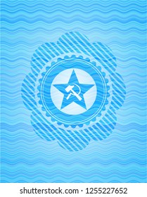 communism icon inside light blue water style emblem.