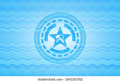 communism icon inside light blue water wave emblem.