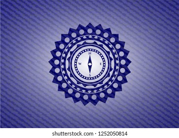 compass icon inside badge with denim background