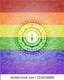 compass icon inside emblem on mosaic background with the colors of the LGBT flag