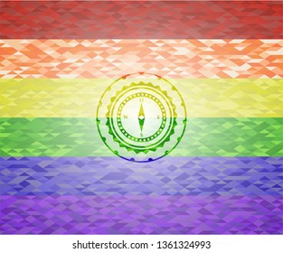 compass icon inside emblem on mosaic background with the colors of the LGBT flag