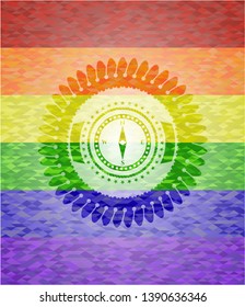 compass icon inside emblem on mosaic background with the colors of the LGBT flag