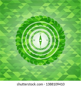 compass icon inside green emblem with triangle mosaic background