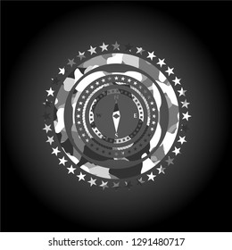 compass icon inside grey camouflage emblem